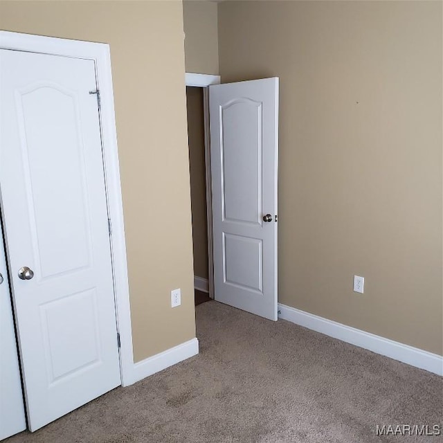 unfurnished bedroom with carpet and baseboards