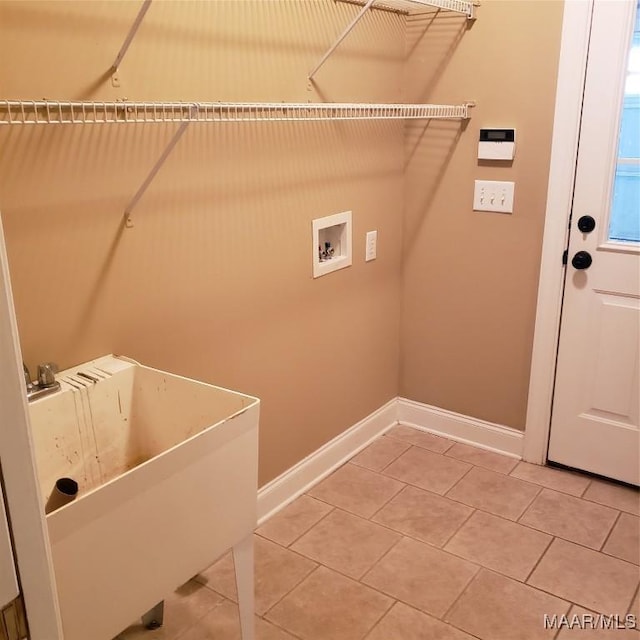 washroom featuring light tile patterned flooring, laundry area, washer hookup, a sink, and baseboards