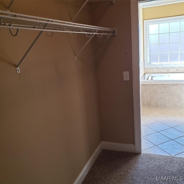 spacious closet featuring tile patterned flooring and carpet flooring