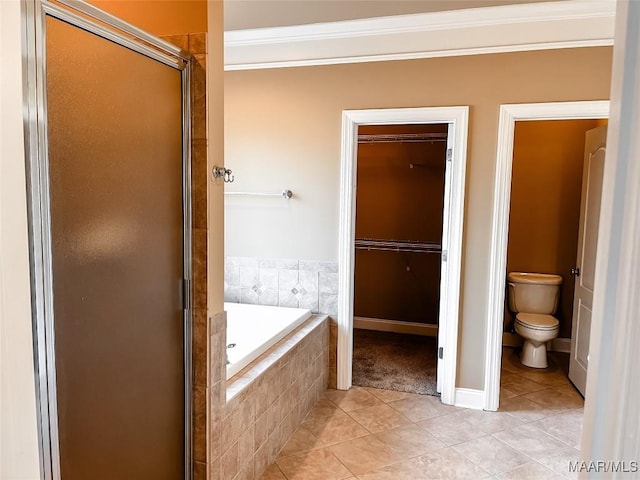 bathroom featuring a stall shower, toilet, tile patterned floors, a garden tub, and crown molding