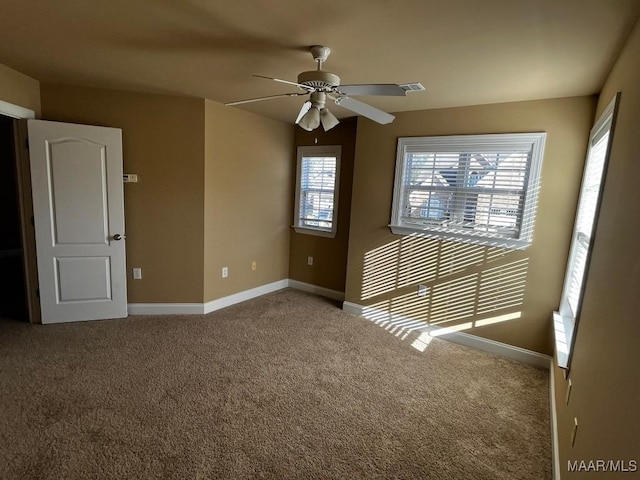 carpeted spare room with visible vents, ceiling fan, and baseboards