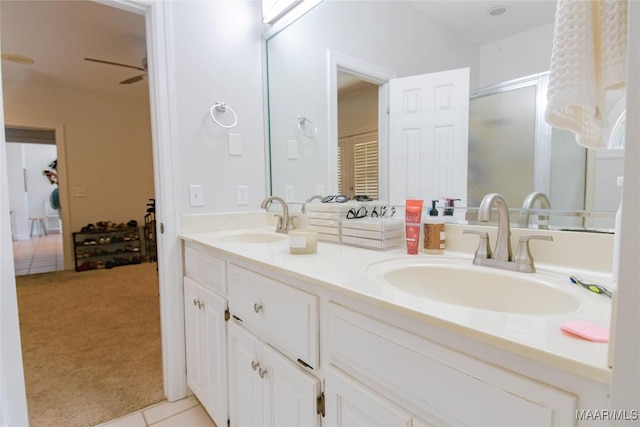 bathroom with double vanity, a ceiling fan, a sink, and a shower with shower door