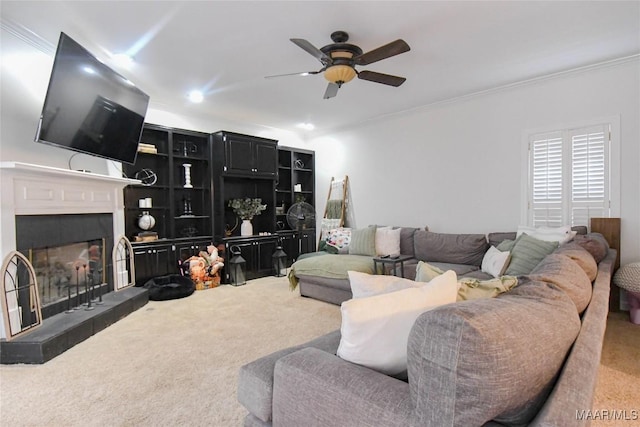 carpeted living room with ceiling fan, crown molding, and a tile fireplace