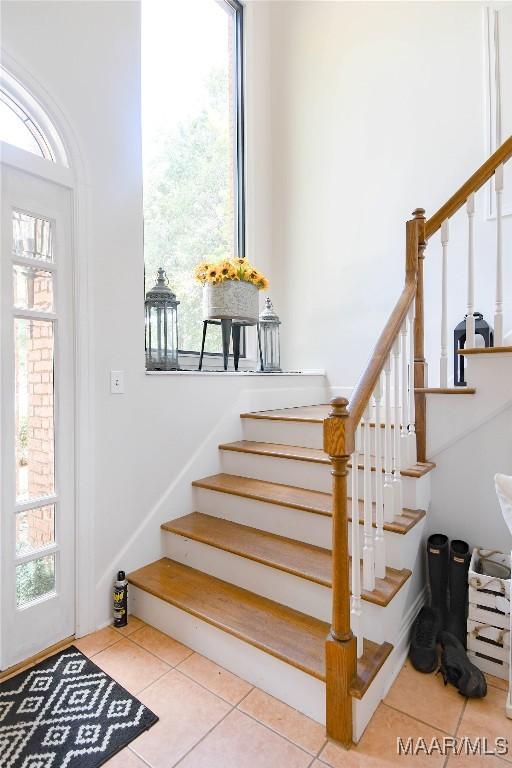 staircase featuring tile patterned flooring and a healthy amount of sunlight