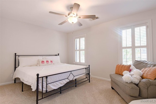 bedroom featuring a ceiling fan, light carpet, visible vents, and baseboards