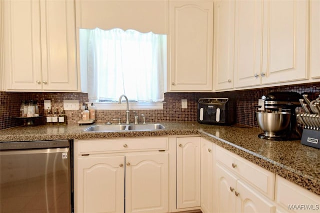 kitchen with stainless steel dishwasher, a sink, white cabinetry, and decorative backsplash