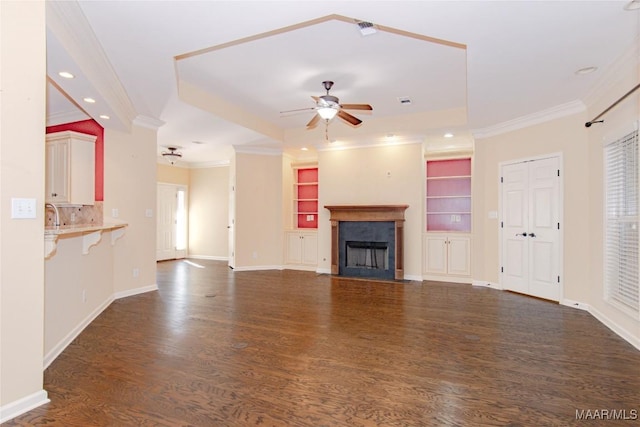 unfurnished living room with ceiling fan, dark wood-style flooring, a fireplace with flush hearth, and crown molding