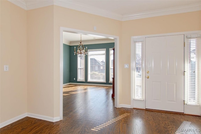 foyer entrance with a chandelier, dark wood finished floors, baseboards, and ornamental molding