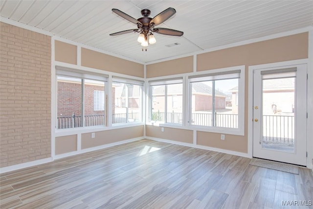 unfurnished sunroom with visible vents and a ceiling fan