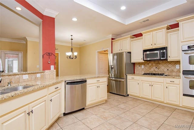 kitchen with cream cabinetry, stainless steel appliances, visible vents, hanging light fixtures, and a chandelier