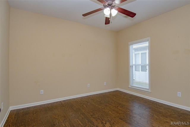 spare room featuring ceiling fan, baseboards, and dark wood-style flooring