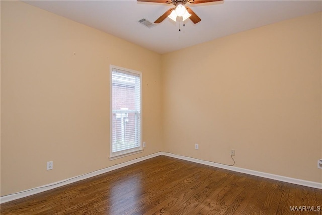 unfurnished room featuring baseboards, dark wood-style flooring, visible vents, and a ceiling fan