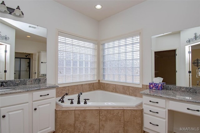 bathroom with a sink, two vanities, visible vents, a shower stall, and a bath