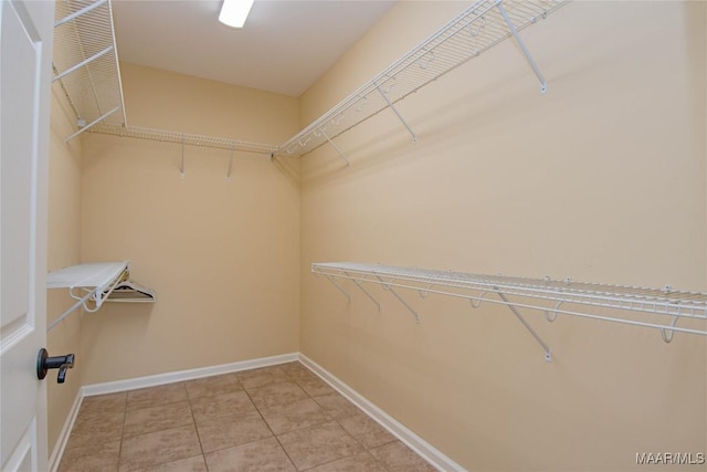 walk in closet with light tile patterned floors