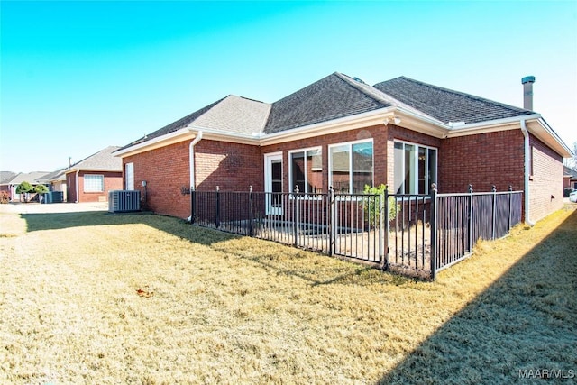 view of property exterior with a yard, fence, central AC, and brick siding