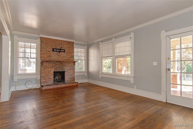 unfurnished living room featuring a brick fireplace, baseboards, crown molding, and wood finished floors