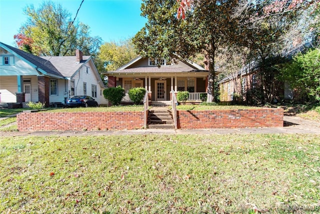 view of front of house featuring covered porch and a front yard