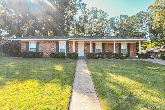 ranch-style home with covered porch, a front lawn, and brick siding