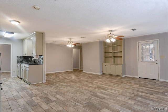 unfurnished living room featuring a textured ceiling, baseboards, a ceiling fan, and light wood-style floors