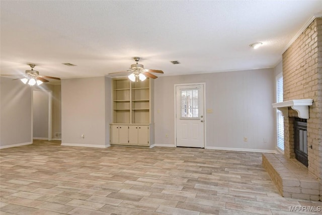 unfurnished living room featuring a ceiling fan, a brick fireplace, a textured ceiling, and light wood finished floors