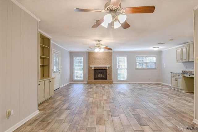 unfurnished living room featuring ornamental molding, light wood-type flooring, and plenty of natural light