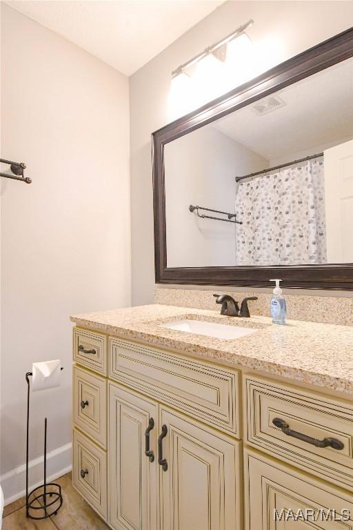 bathroom with visible vents, vanity, and baseboards