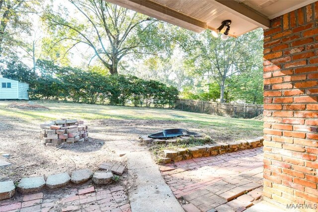 view of yard featuring an outdoor fire pit, a patio area, and fence