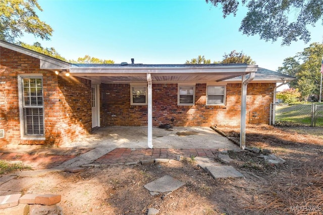 back of house with a patio, brick siding, and fence