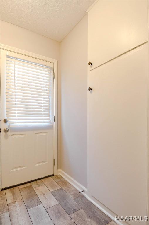 entryway with baseboards and a textured ceiling