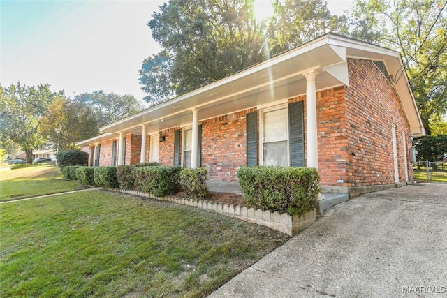 view of home's exterior with a lawn and brick siding