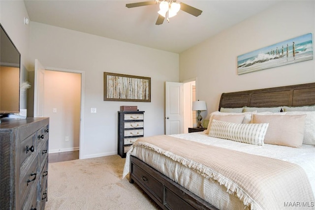 bedroom with baseboards, a ceiling fan, and light colored carpet