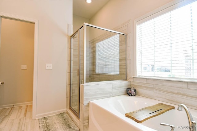 full bath featuring a stall shower, baseboards, and a garden tub