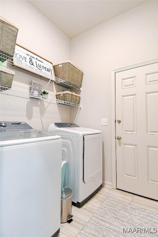 washroom with laundry area, light wood finished floors, and washer and clothes dryer