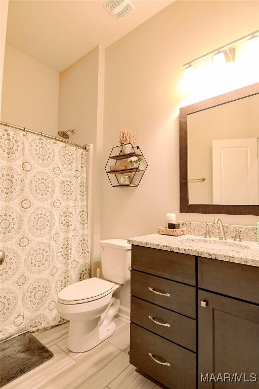 full bath with toilet, baseboards, visible vents, and vanity