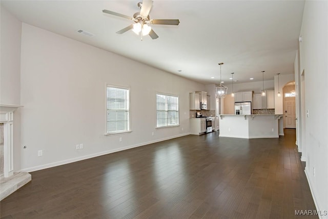 unfurnished living room featuring ceiling fan, dark wood-style flooring, a high end fireplace, and visible vents