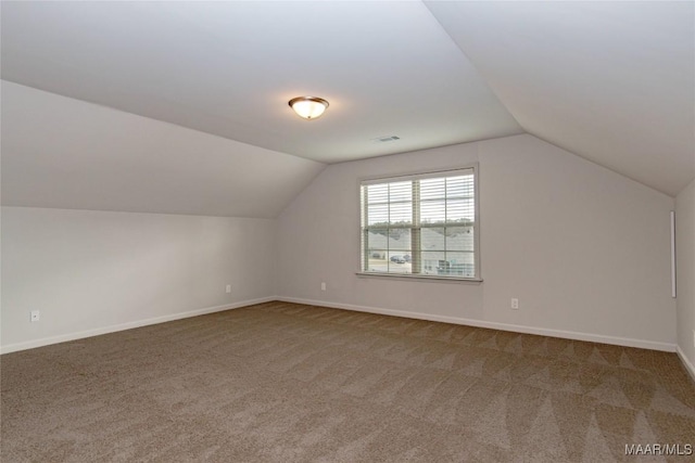 additional living space featuring vaulted ceiling, carpet flooring, and baseboards