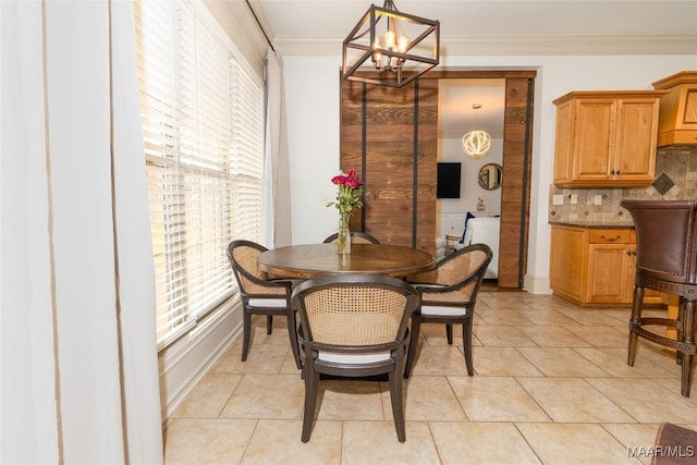 dining space featuring an inviting chandelier, baseboards, crown molding, and light tile patterned flooring