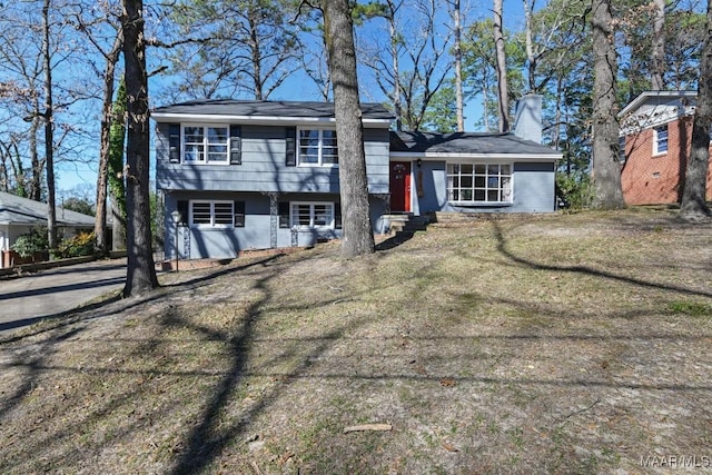 view of front of home with a chimney and a front yard