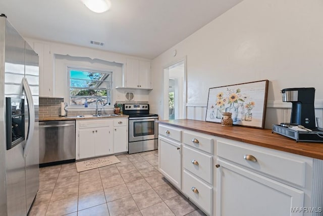 kitchen featuring white cabinetry, visible vents, stainless steel appliances, and a sink