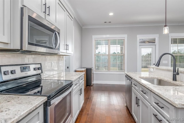 kitchen featuring crown molding, stainless steel appliances, a sink, and white cabinets