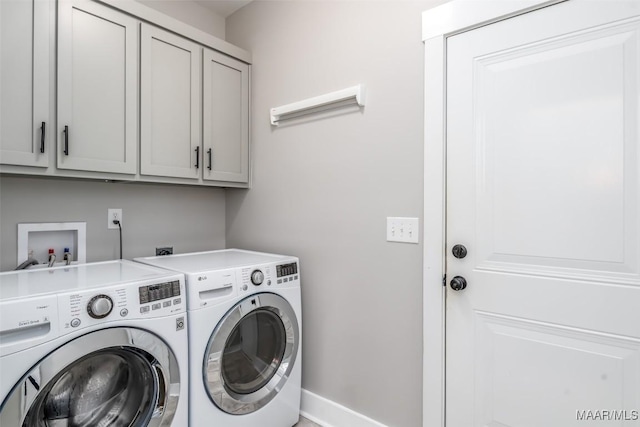 washroom featuring baseboards, cabinet space, and washing machine and clothes dryer