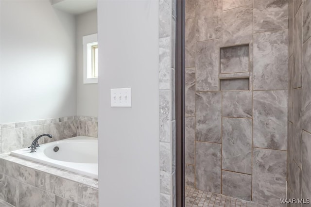 bathroom featuring a stall shower and a bath