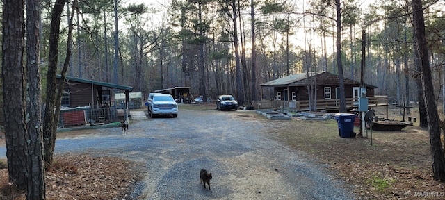 view of road featuring driveway and a forest view