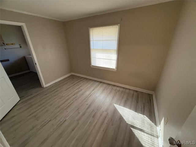 unfurnished bedroom with baseboards, wood finished floors, and ornamental molding