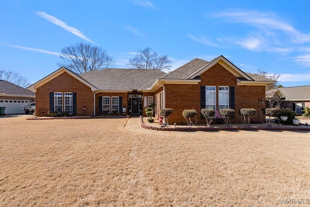 ranch-style home featuring a shingled roof and brick siding