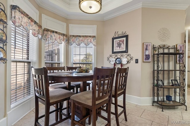 dining room featuring light tile patterned floors, baseboards, and crown molding