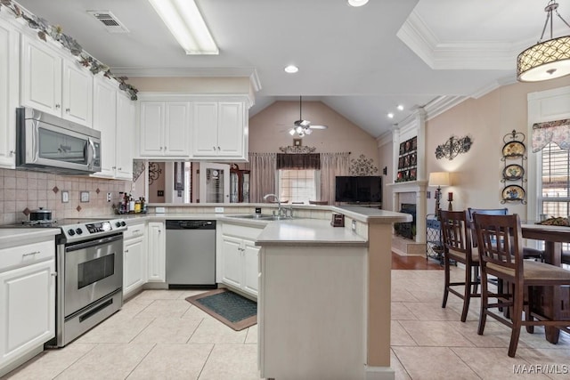 kitchen with stainless steel appliances, visible vents, light countertops, a sink, and a peninsula