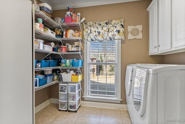 laundry room with cabinet space, baseboards, light tile patterned flooring, and washing machine and clothes dryer