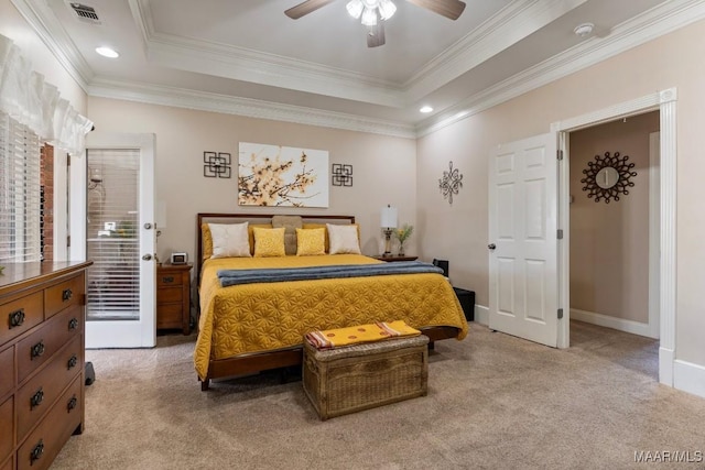 bedroom with light carpet, visible vents, baseboards, a tray ceiling, and crown molding