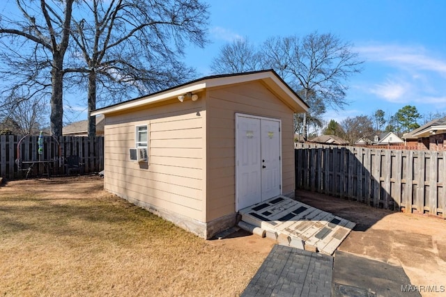 view of shed with cooling unit and a fenced backyard